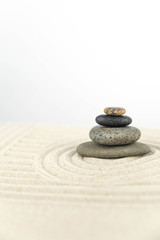 Zen garden. Pyramids of white and gray zen stones on the white sand with abstract wave drawings. Concept of harmony, balance and meditation, spa, massage, relax.