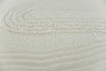 Fototapeta na wymiar Abstract Zen drawing on white sand. Concept of harmony, balance and meditation, spa, massage, relax. Zen garden