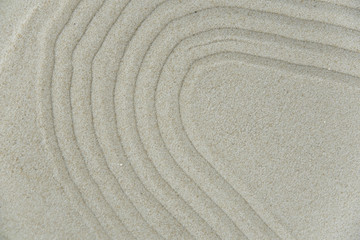 Fototapeta na wymiar Abstract Zen drawing on white sand. Concept of harmony, balance and meditation, spa, massage, relax. Zen garden.