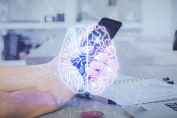 Double exposure of man's hand holding and using a digital device and brain hologram drawing. Data concept.