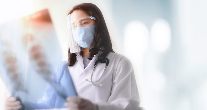 asian female doctor looking at the x-ray picture of lungs in hospital