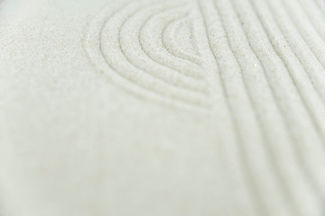 Fototapeta na wymiar Abstract Zen drawing on white sand. Concept of harmony, balance and meditation, spa, massage, relax. Zen garden.