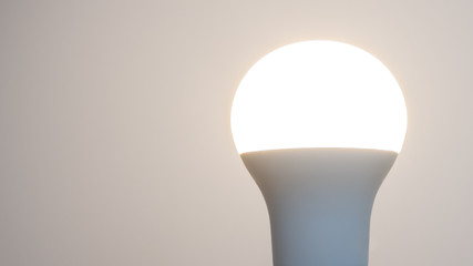 Glowing smart light bulb. Copy space on left.