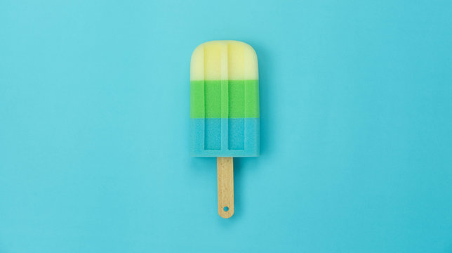 Table top view aerial image of sign or food of summer season holiday background concept.Flat lay of pastel sweet ice cream on modern rustic yellow paper backdrop.Minimalism and copy space design word.