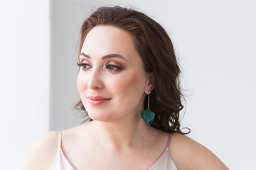 Fototapeta premium Close-up portrait of beautiful young woman with elegant hairstyle and luxurious jewelry and bijouterie.