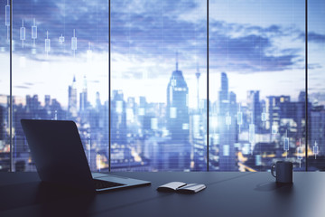 Laptop on table in office with stock market crash statistics hologram