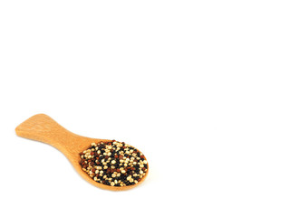 Organic tri-color Quinoa in wooden spoon isolated on a white background. High fiber, Superfood..