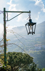Lamp covered in vines with mountain behind at the hill-town Rivello, Italy.