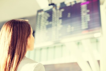 Portrait of Young attractive businesswoman looking at her flight on screen