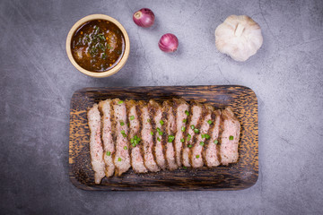 Beef grill with Thai spicy sauce on wooden plate