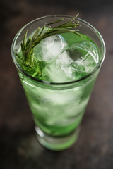 Sweet tequila based green cocktail with tarragon and rosemary. Selective focus. Shallow depth of field.