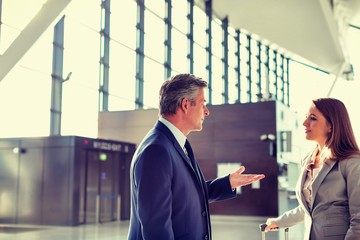 Fototapeta premium Businessman talking to businesswoman in airport