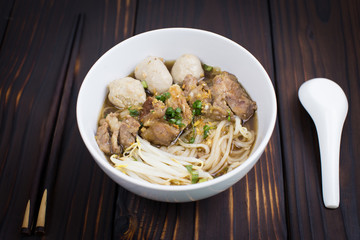 Beef noodles soup and meatballs on wooden background