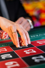 Naklejka premium Woman playing roulette at the casino