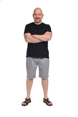 Bald man with sandals t-shirt and shorts, arms crossed