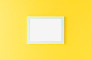 Blue picture frame on yellow background. Mockup with copyspace