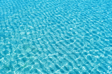 Background shot of aqua water surface. Swimming pool with sunny reflections.