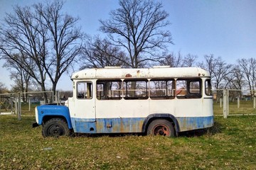 Old school bus in yard in village at spring