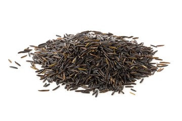 Heap of uncooked, raw, black wild rice grains over white