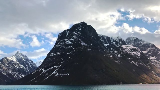 Mountain View in Hj&oslash;rundfjord in Western Norway. With amazing sky in the spring filmed from the ferry to Sk&aring;r. Snow covered mountains in &Oslash;rsta and Volda in More og Romsdal.
