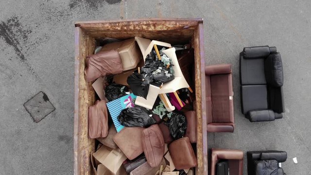 Big Industrial Skip Full Of Old Furnitures And General Waste. - top view shot
