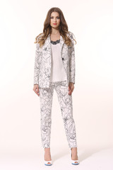 business woman executive posing in summer print white pant suit full body length