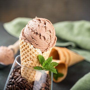 Delicious coffee or chocolate ice cream in waffle cone for dessert. Summer healthy food concept, lactose free. Copy space.