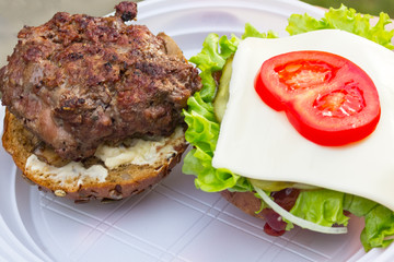Yummy Burger made from meat, green salad, onions, sauce with spices and tomatoes looks delicious. cook it yourself during the holidays