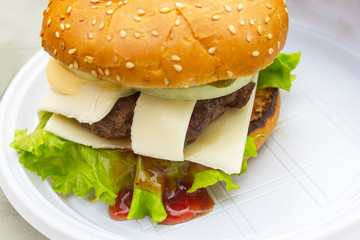 appetizing fresh homemade burger with meat, cheese and lettuce on a wooden table. Delicious fast food concept.  hamburger day cancelled
