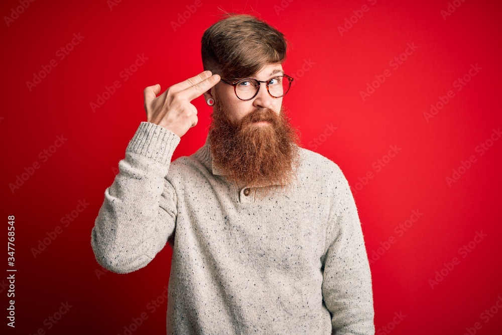 Canvas Prints handsome irish redhead man with beard wearing casual sweater and glasses over red background shootin