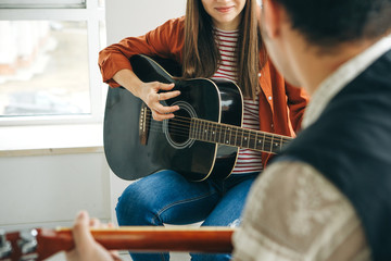 Learning to play the guitar. The teacher explains to the student the basics of playing the guitar....