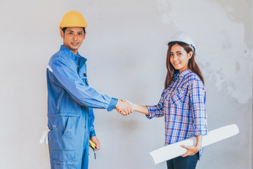 Engineering and worker with helmet handshake together to agree j