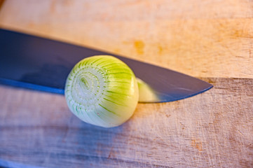 preparing onion on a wooden cutting board