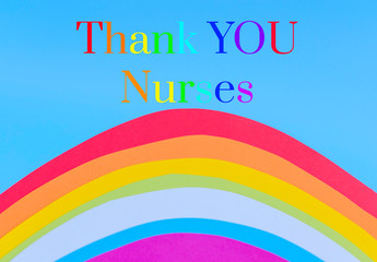 rainbow cut out of colored paper on a blue background with text Thank you nurses who are frontline workers during the coronavirus pandemic