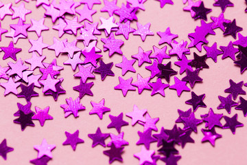 Obraz na płótnie Canvas Closeup asterisks sprinkled on a pink isolated background. View from above.