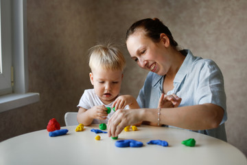 Fototapeta premium mother sculpts with baby from children's dough