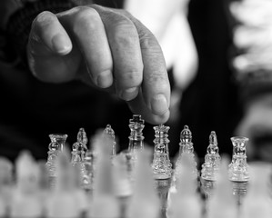 Mano de hombre adulto se dispone a coger una pieza blanca de ajedrez
