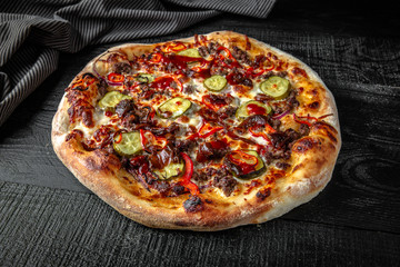 Tasty hot italian pizza vegetarian with eggplant, zucchini, tomatoes on black wooden table. Pizzeria menu. Concept poster for Restaurants or pizzerias