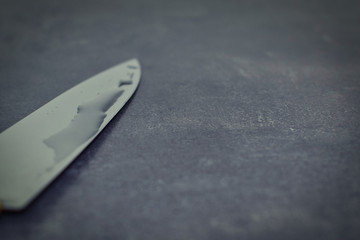 knife blade with water on it on a wooden table of gray pattern  