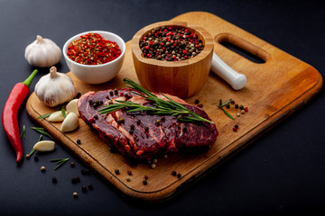 Fresh steak with a set of spices on a cutting board