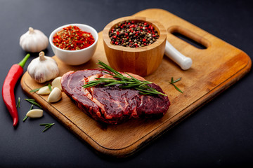 Fresh steak with a set of spices on a cutting board