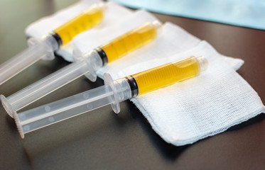 Blood plasma as a hope for treatment of coronavirus infection. Syringes with Platelet-Rich plasma preparation for plasmolifting therapy. Selective Focus. - obrazy, fototapety, plakaty
