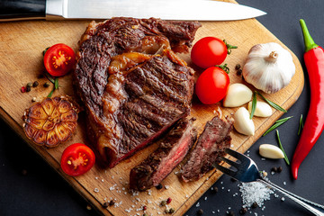 Fresh juicy ribeye steak with a set of spices on a cutting board