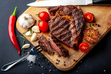 Fresh juicy ribeye steak with a set of spices on a cutting board