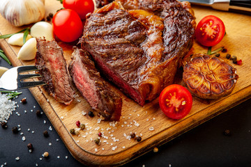 Fresh juicy ribeye steak with a set of spices on a cutting board