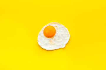 Fried egg on yellow background top view