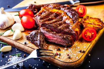 Fresh juicy ribeye steak with a set of spices on a cutting board