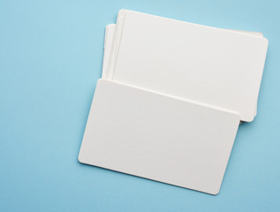 stack of rectangular white paper blank business cards on blue background