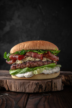 Delicious juicy burger from Brioche Bun, aged beef cutlet, bacon, Dorblu cheese, tomatoes, gherkins, iceberg, onion marmalade Hamburger for poster or menu. 