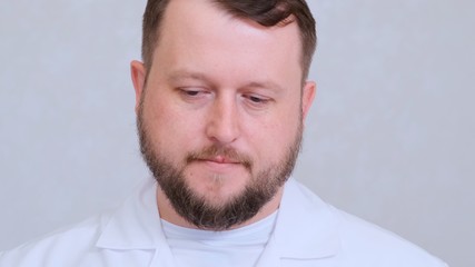 bearded man doctor lowers his head, the concept of medical treatment and diagnosis.